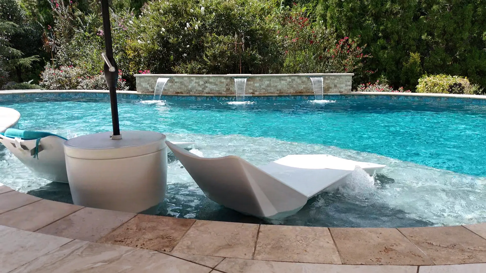 Wide view of the completed Curtis project in Atlanta with a pool, round raised spa, tanning ledge, and curved wall with two water features