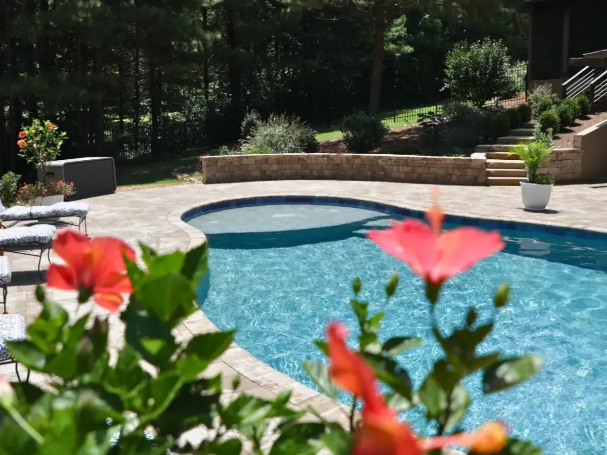 Dallas RutherfordMade custom pool with tanning ledge, flowers, and stone surround