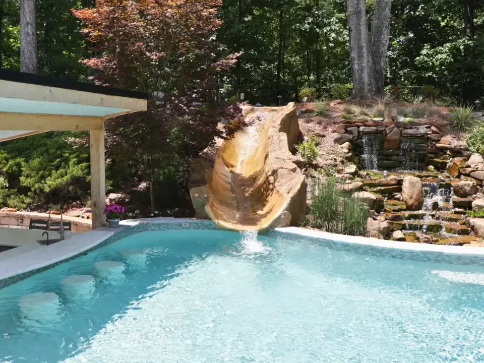 RutherfordMade pool with rock slide, waterfall, patio, and landscape stonework